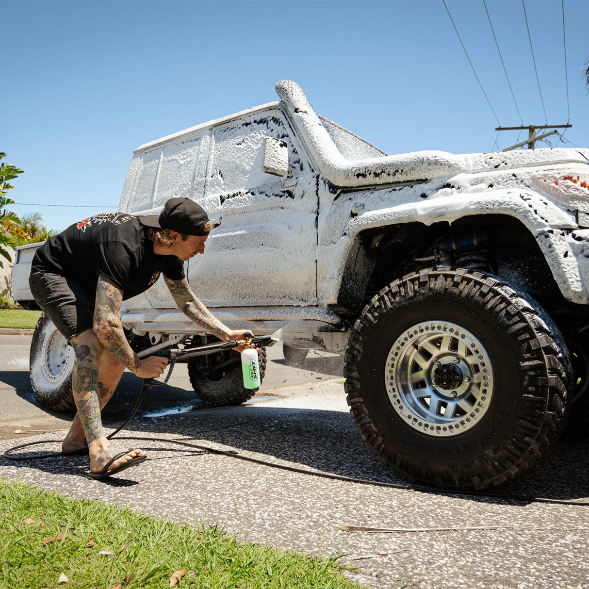 4WD ute covered in thick foam wash, breaking down dirt and grime for a deep clean.