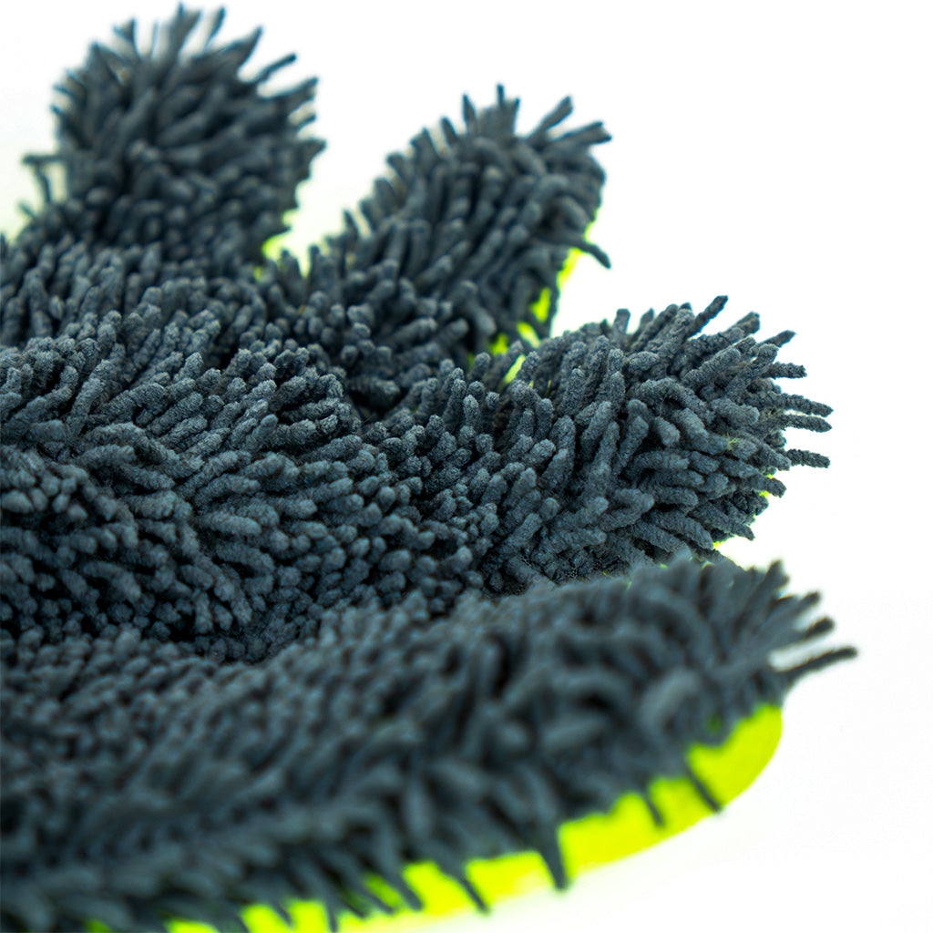 Close-up of a dark gray microfiber cleaning cloth with green edges on a white background