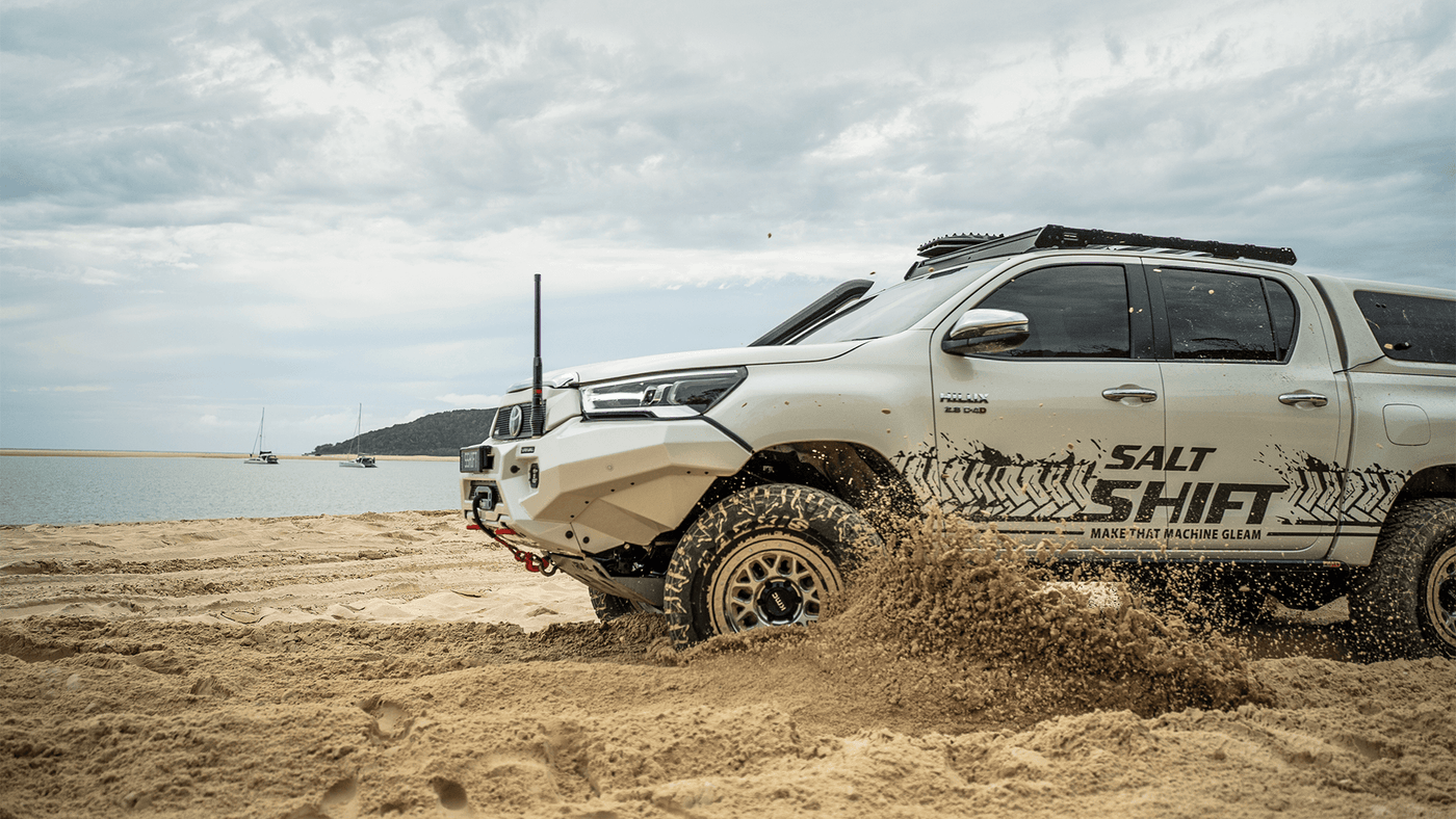 White off-road vehicle with 'Salt Shift' branding on a sandy beach.