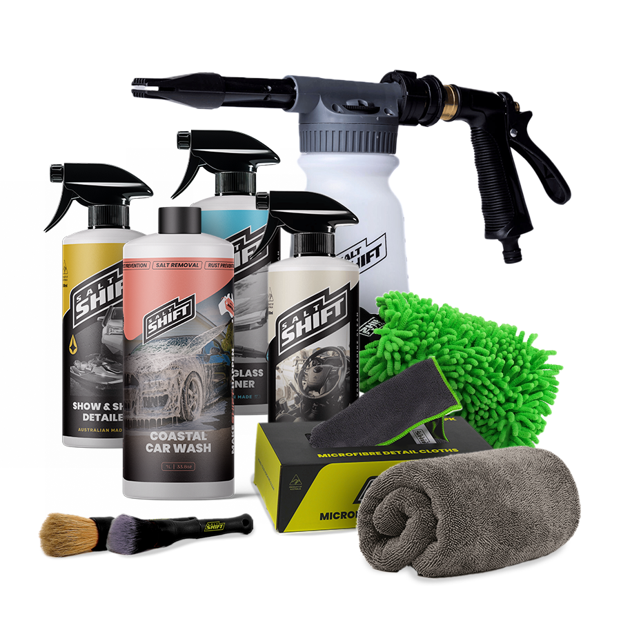 Car wash kit with a bottle, spray gun, towel, and brush on a white background