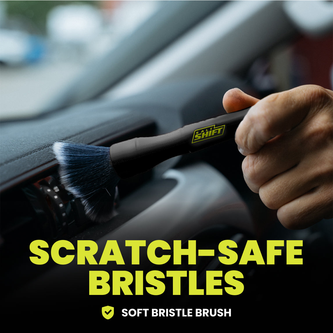 Hand using a soft bristle brush to clean car interior with 'Shift' branding, text 'Scratch-Safe Bristles' displayed.