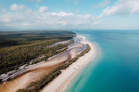 Aerial view of a coastal landscape with a river mouth and sandy beach.