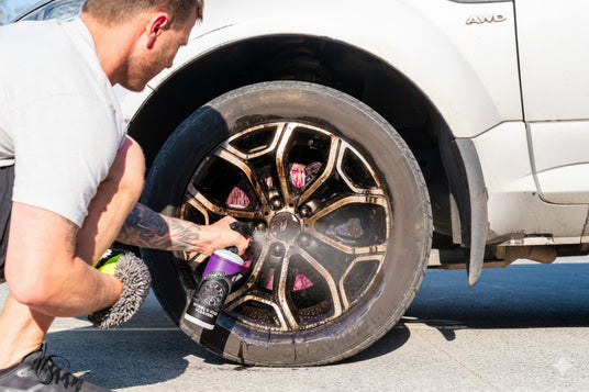 Person cleaning a car wheel