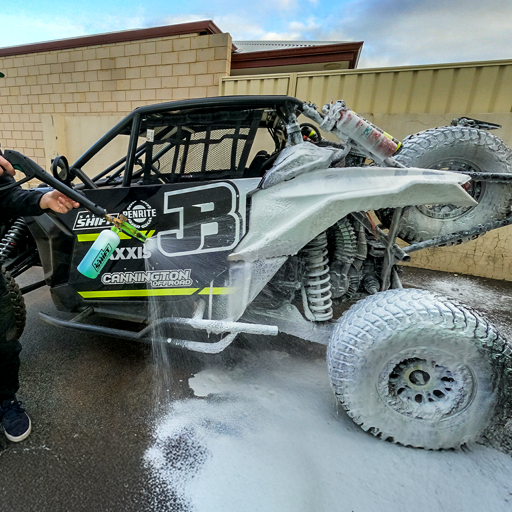 Off-road vehicle being washed with soap suds on a driveway
