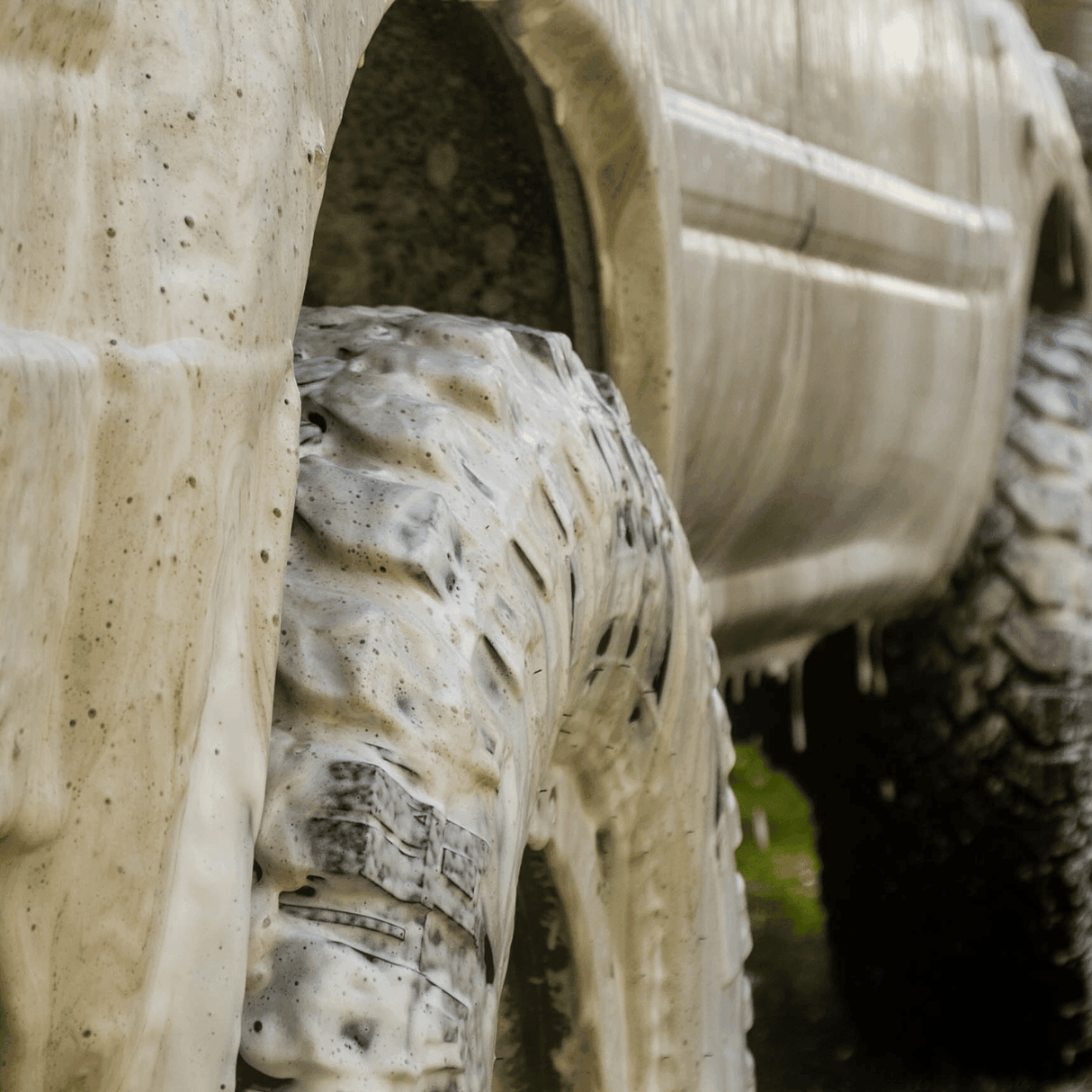 4WD ute covered in thick foam wash, breaking down dirt and grime for a deep clean.