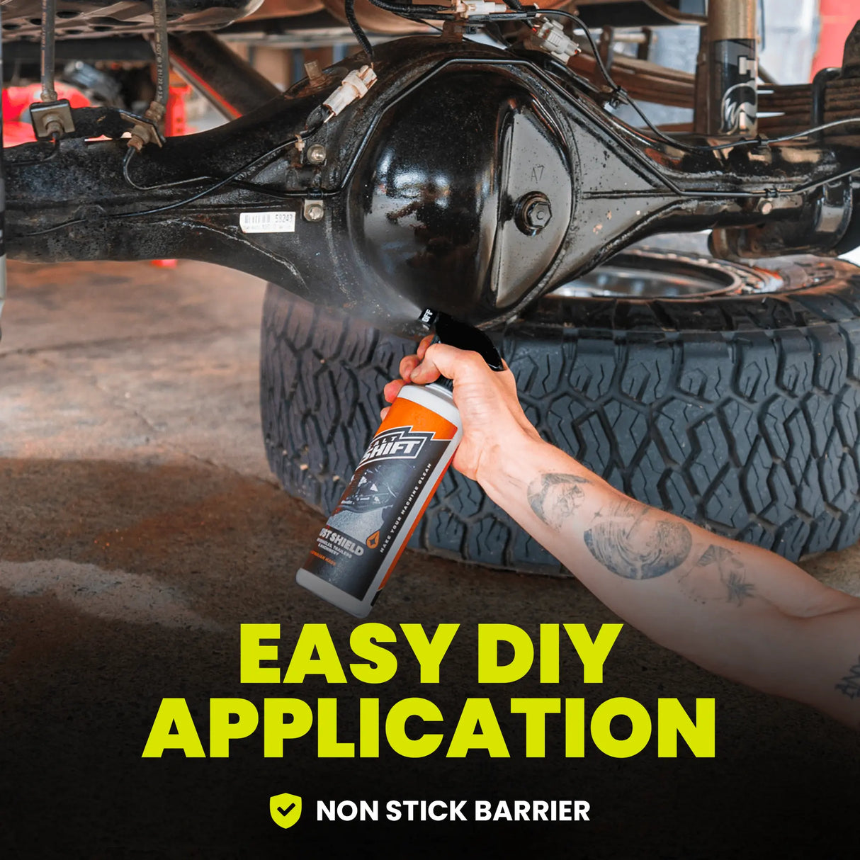 Person applying a non-stick barrier spray to vehicle suspension components.