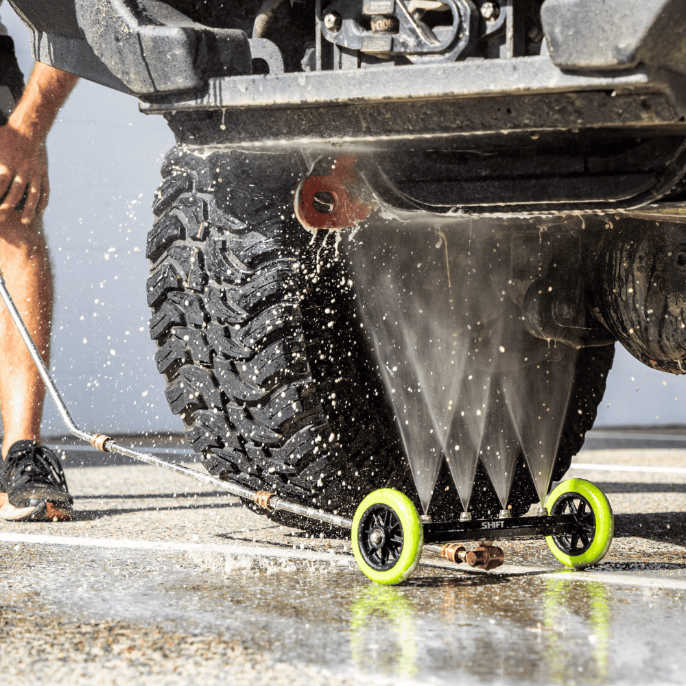Low-pressure underbody wash cleaning a 4x4 vehicle, removing dirt and grime for off-road maintenance and protection.