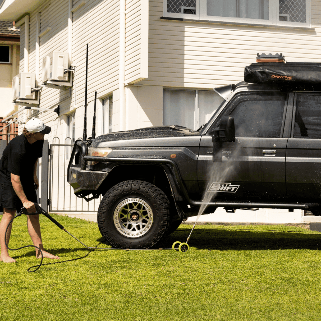 High-pressure underbody wash cleaning a 4x4 vehicle, removing dirt and grime for off-road maintenance and protection.