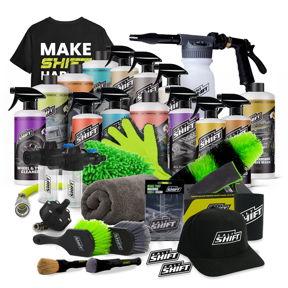 A product bundle of car wash and detailing supplies from Shift Brand, including a black t-shirt, multiple bottles of soap and cleaner, a foam cannon, microfiber cloths, brushes, a towel, and branded caps and patches, arranged on a white background.