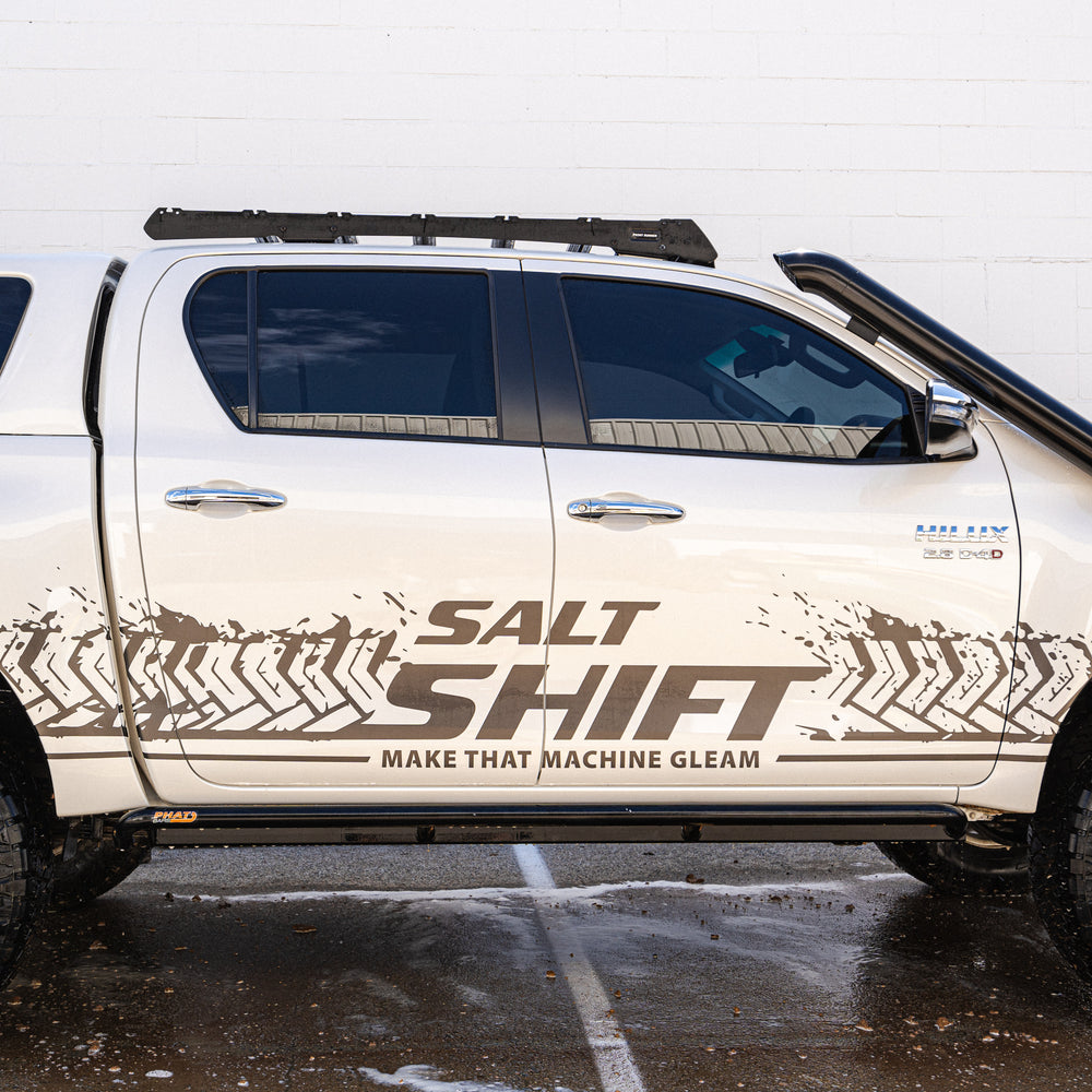 White truck with 'Salt Shift' branding on a wet road