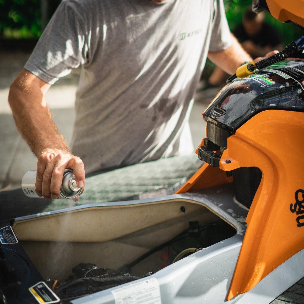 A person sprays Salt Shift Nano Spray on a jetski engine for anti-corrosion protection.