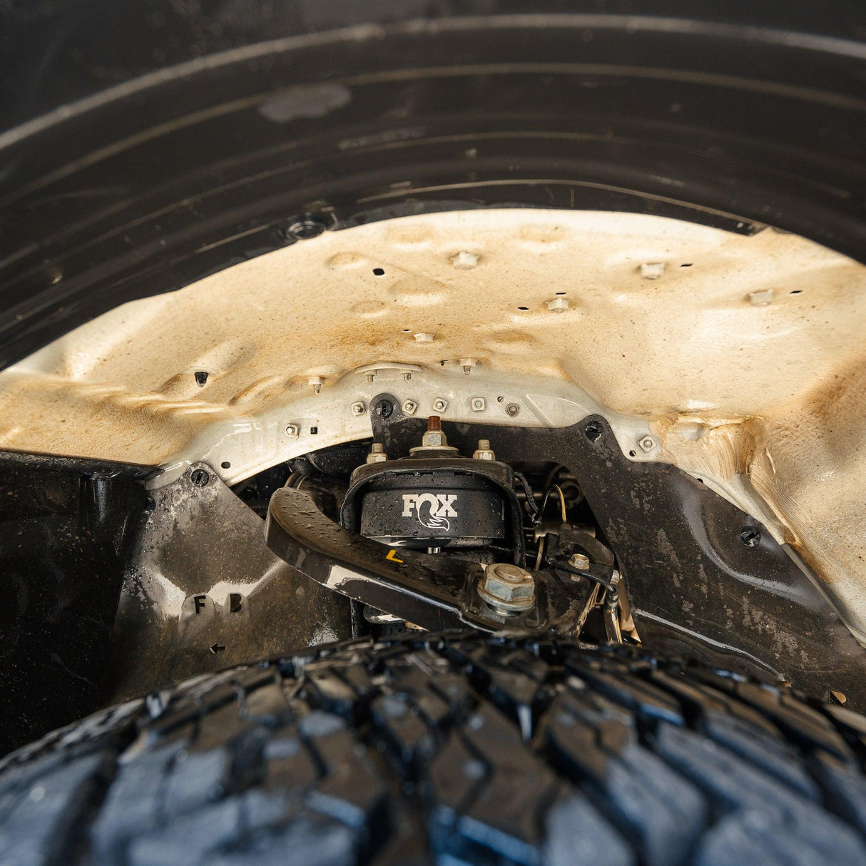 A 4x4 wheel well cleaned by Salt Shift cleaning foam.