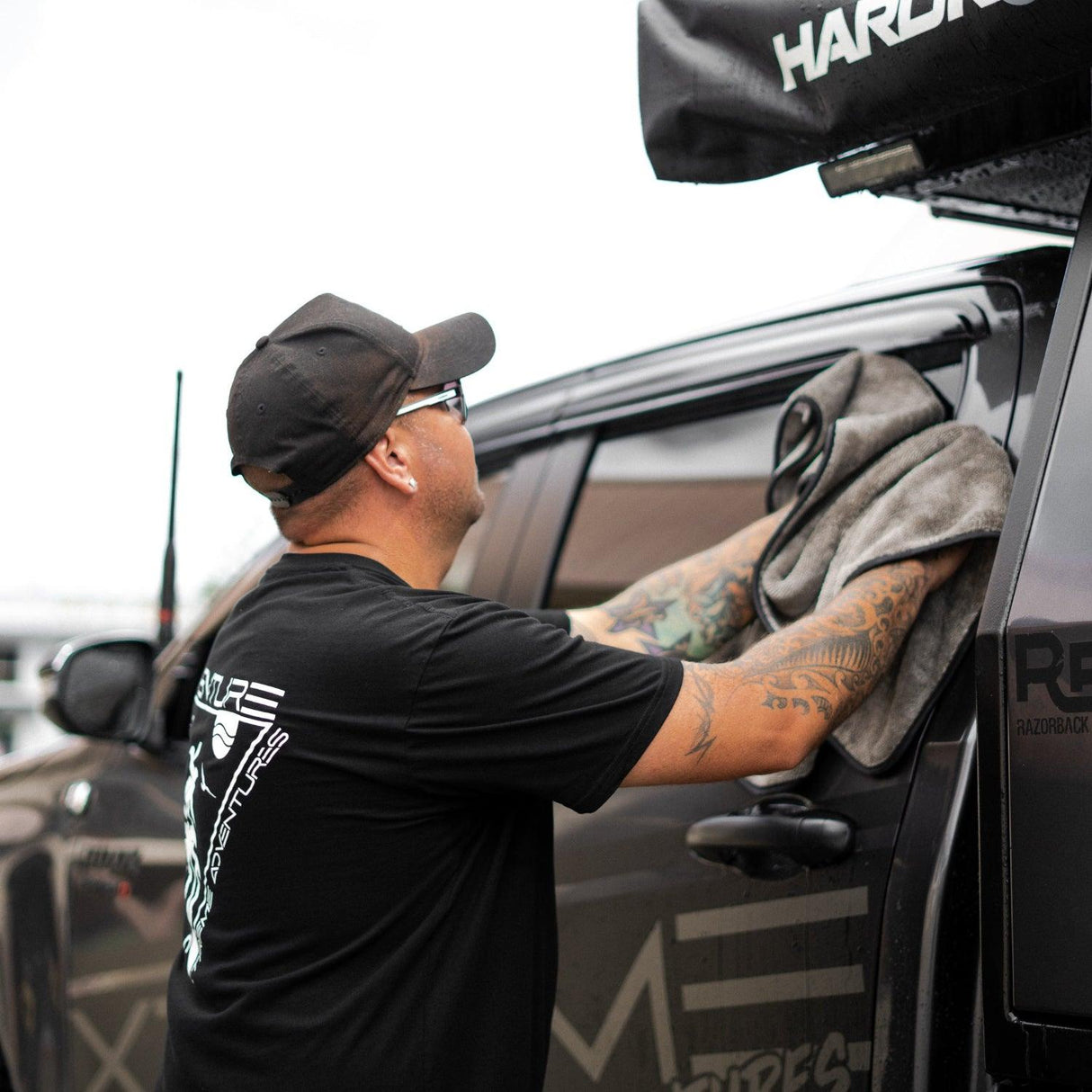 A person wipes down a truck with a grey microfibre towel, ensuring a clean and polished finish.