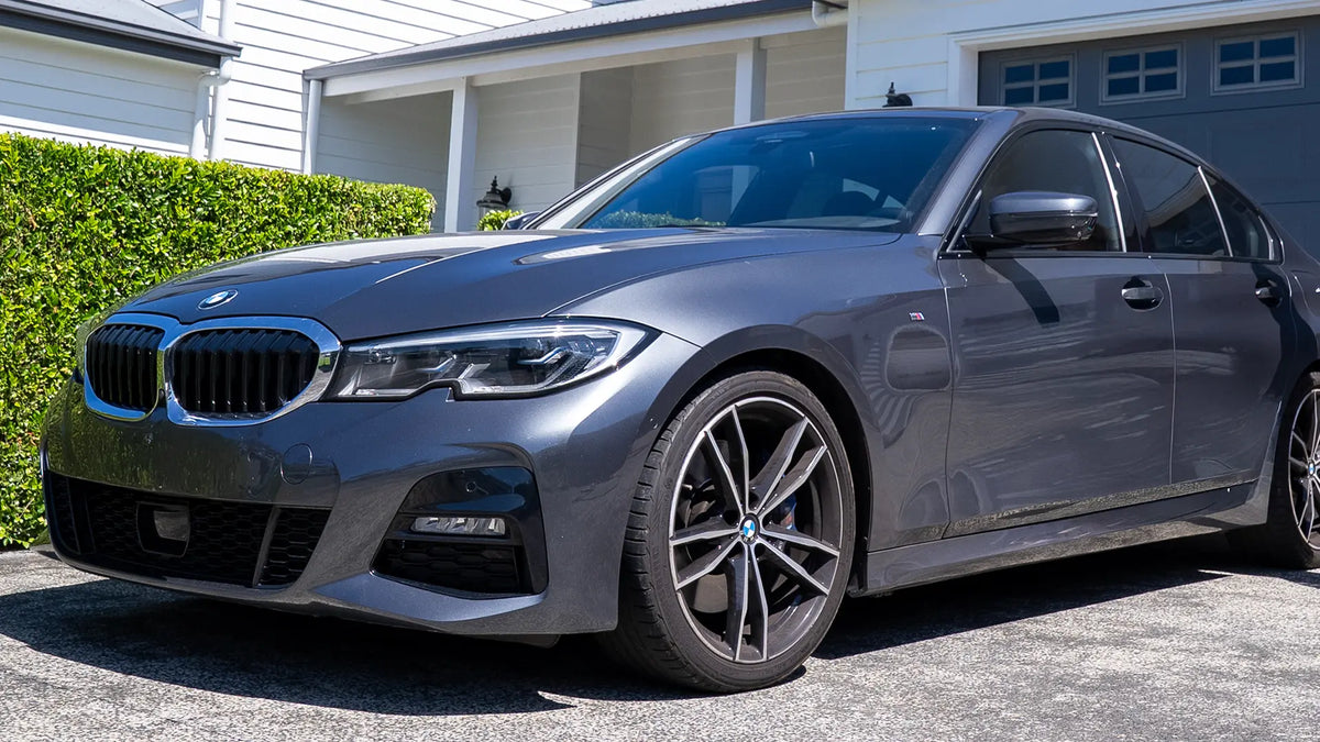 Gray BMW car parked in front of a house