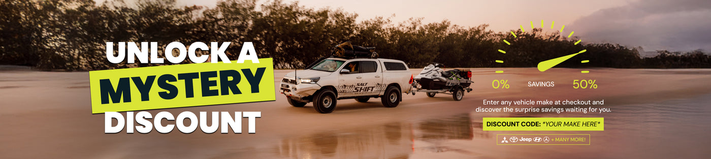 Promotional banner with a truck on a beach, offering a mystery discount with a code.