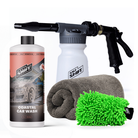 Car wash kit with a bottle, spray gun, towel, and brush on a white background
