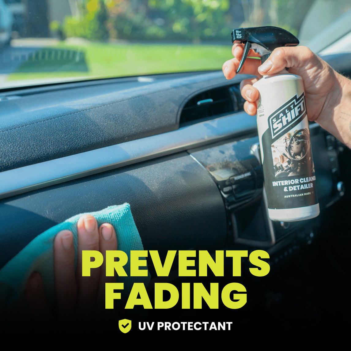 Person cleaning car interior with a spray bottle labeled 'UV Protectant' and a towel.