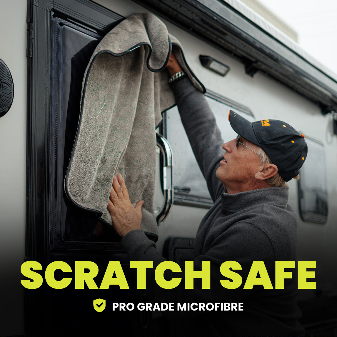 Person cleaning a vehicle window with a microfiber towel, featuring text 'Scratch Safe Pro Grade Microfibre'.