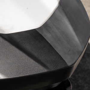 Close-up of a black car bumper with a white edge.