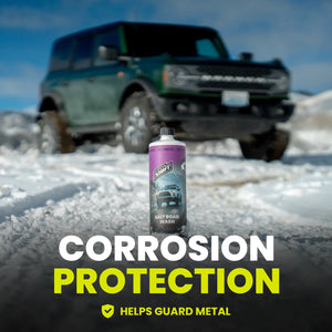 Can of salt road wash with a blurred vehicle in the background on a snowy surface, emphasizing corrosion protection.