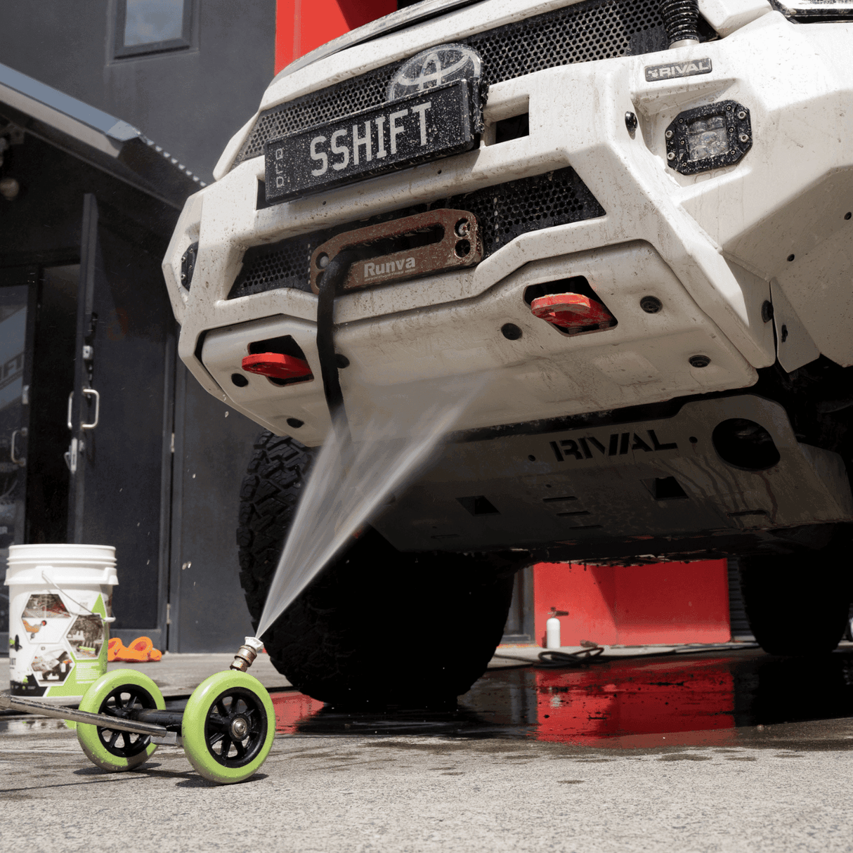 High-pressure underbody wash cleaning a 4x4 vehicle, removing dirt and grime for off-road maintenance and protection.