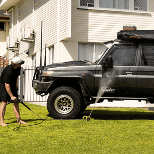High-pressure underbody wash cleaning a 4x4 vehicle, removing dirt and grime for off-road maintenance and protection.