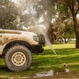 High-pressure underbody wash cleaning a 4x4 vehicle, removing dirt and grime for off-road maintenance and protection.