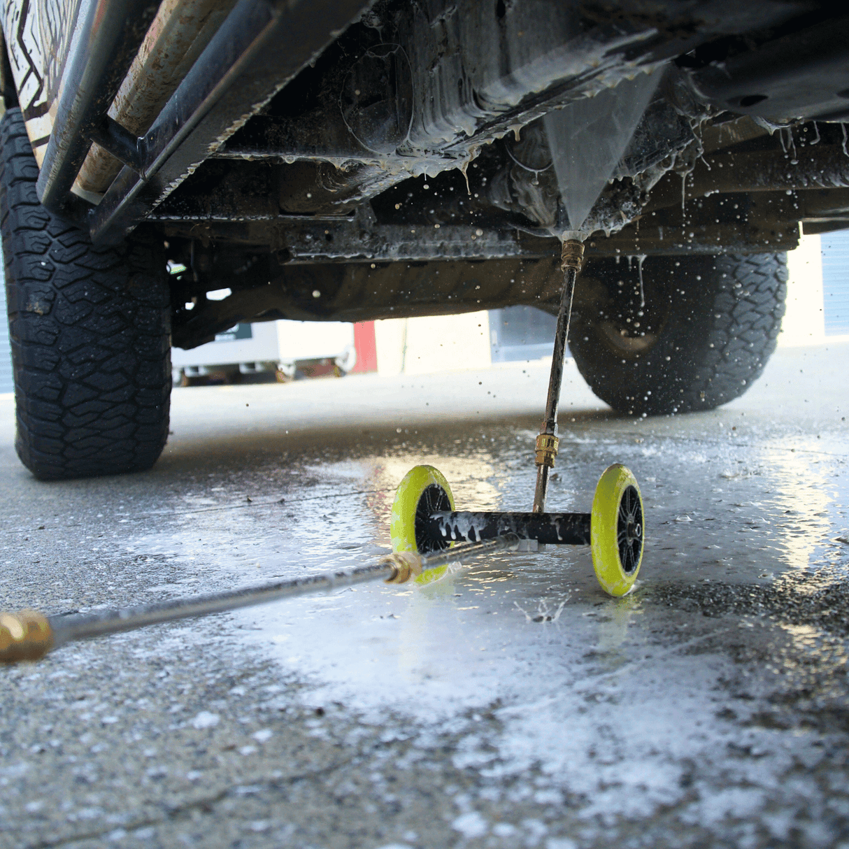 High-pressure underbody wash cleaning a 4x4 vehicle, removing dirt and grime for off-road maintenance and protection.