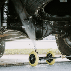 High-pressure underbody wash cleaning a 4x4 vehicle, removing dirt and grime for off-road maintenance and protection.