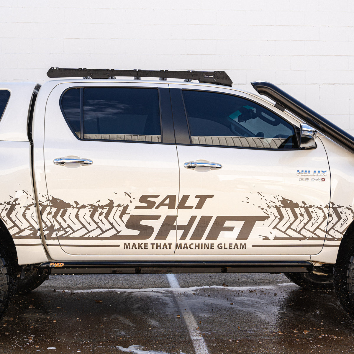 White truck with 'Salt Shift' branding on a wet road