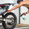 motorcross rider cleaning his dirt bike after riding 