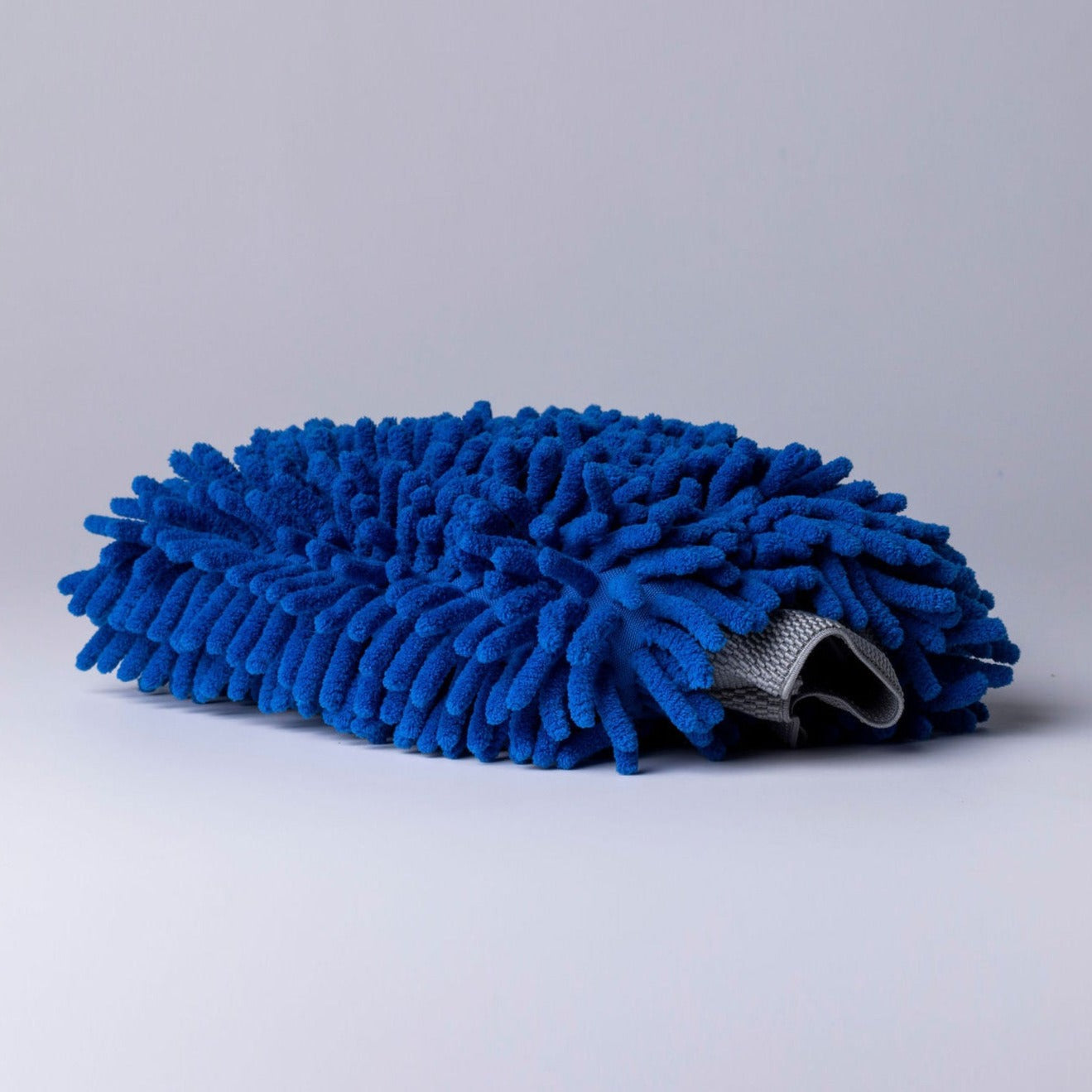 photo of blue microfibre wash mitt with grey background