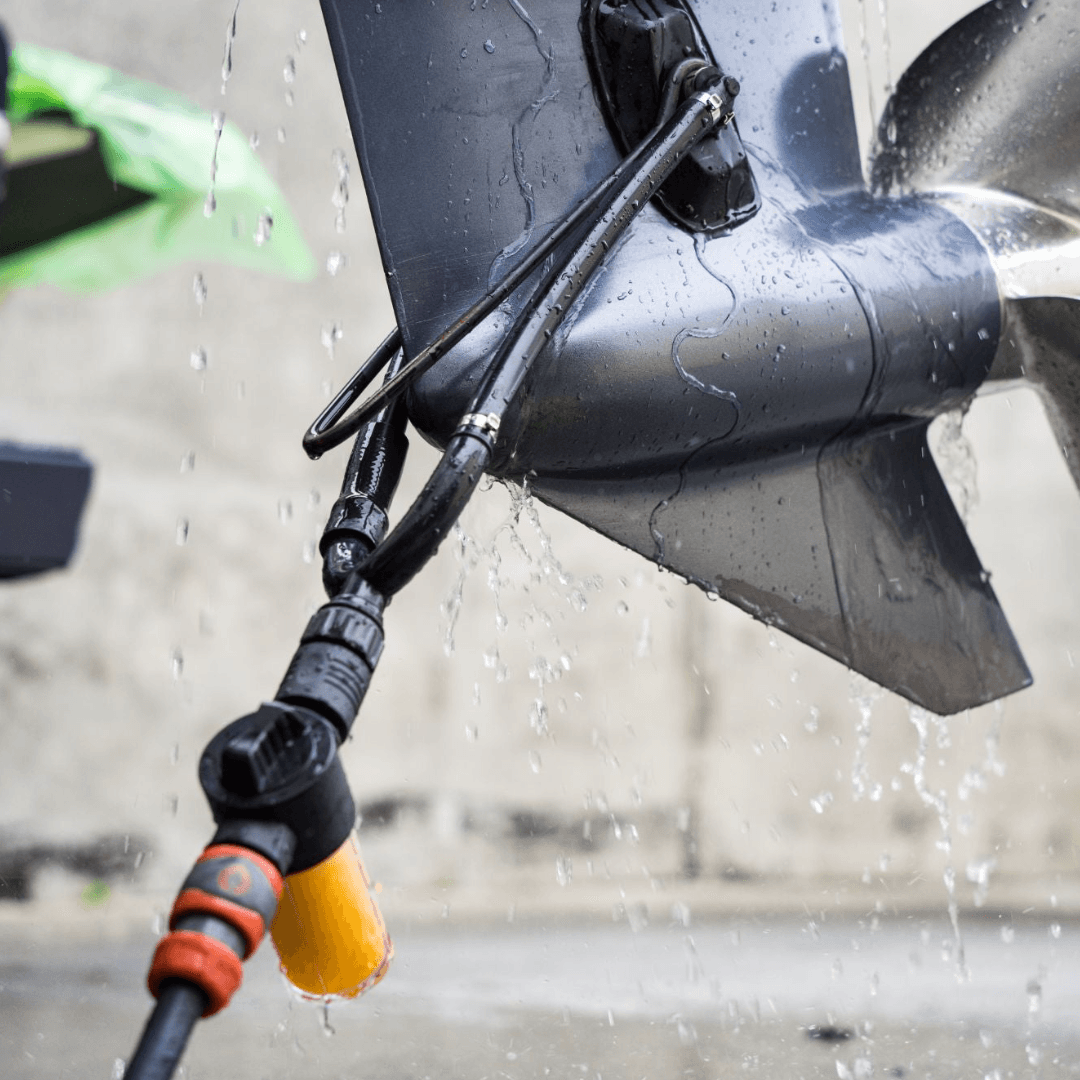 A Salt Shift engine flush system connected to a boat propeller for thorough cleaning.