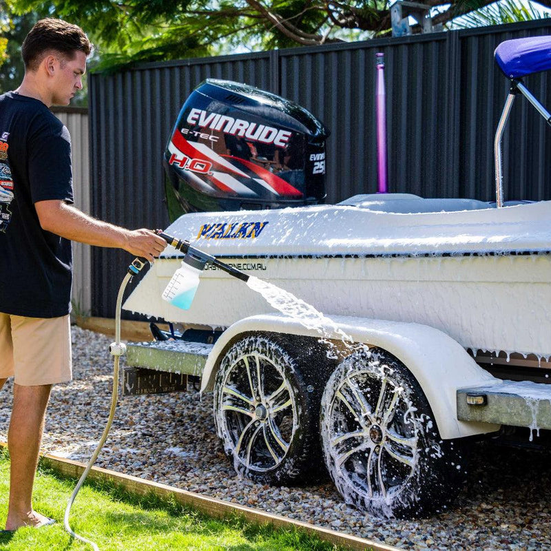 Man using a foam gun to wash a boat with Salt Shift cleaning solution, removing salt and grime for corrosion protection.
